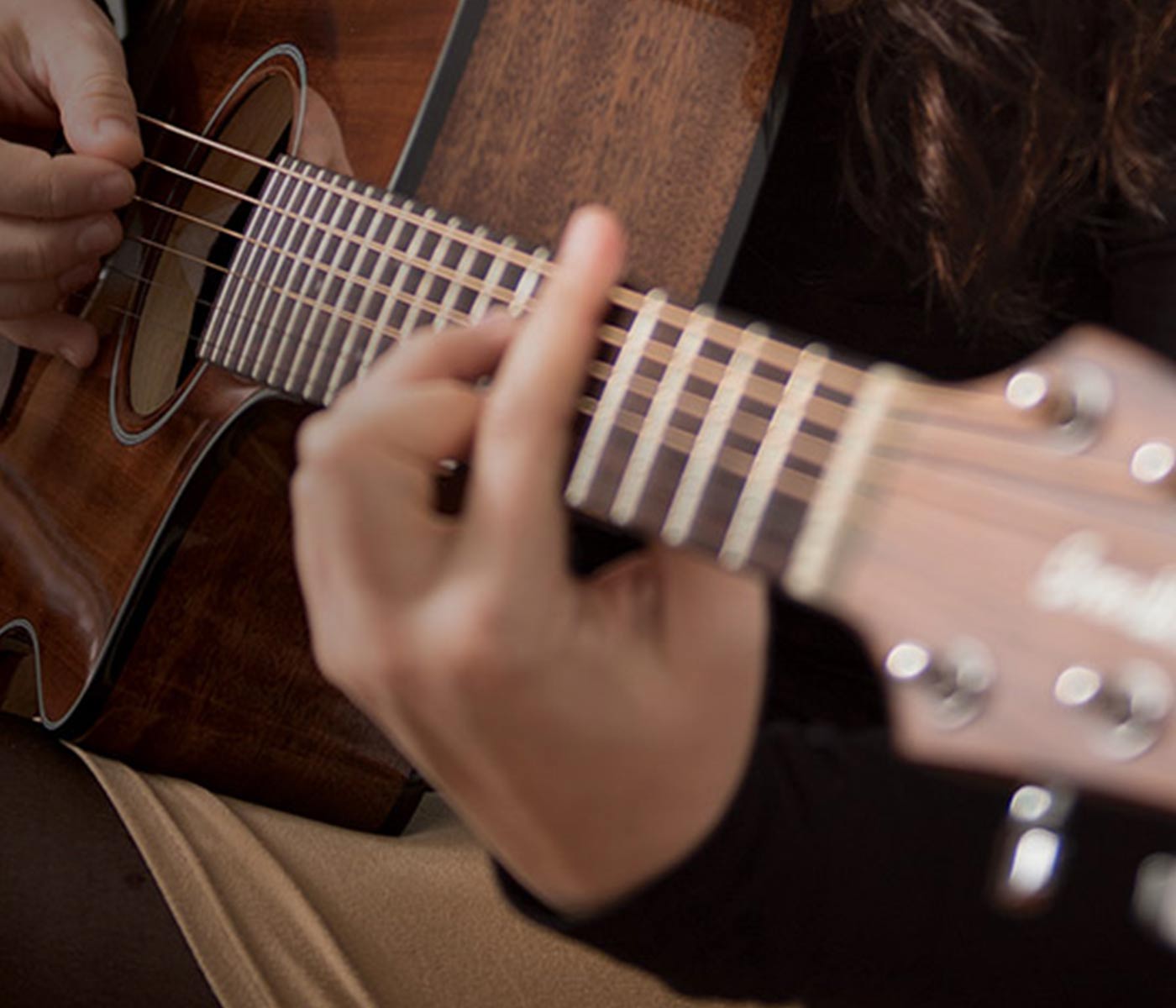 Hands playing a guitar