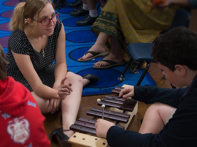 Student with young child playing the marimba