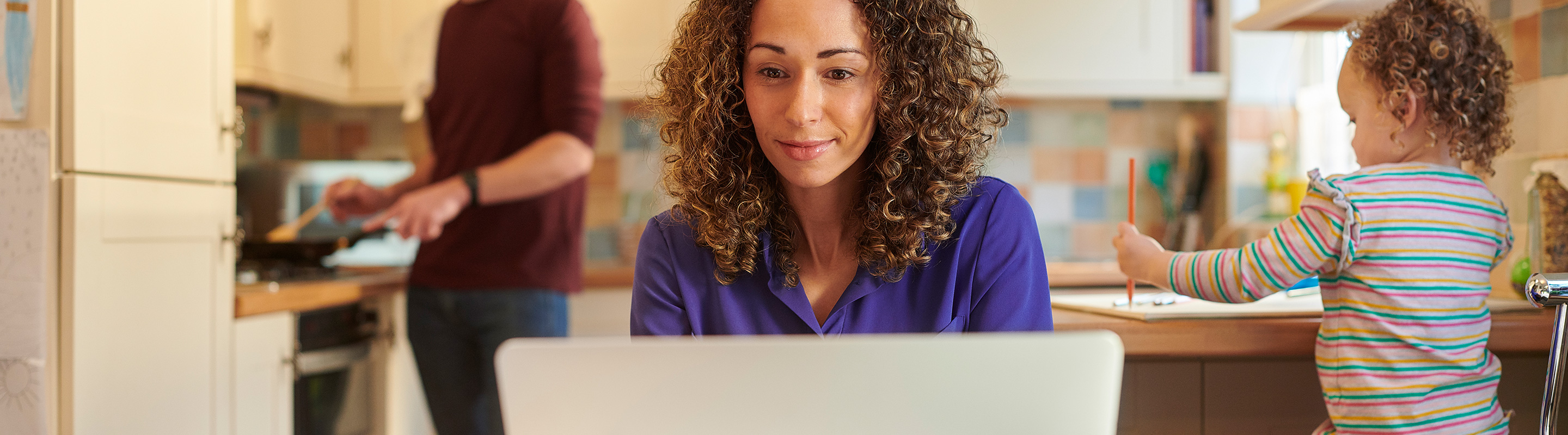 College student and mom studies while her child plays in the background
